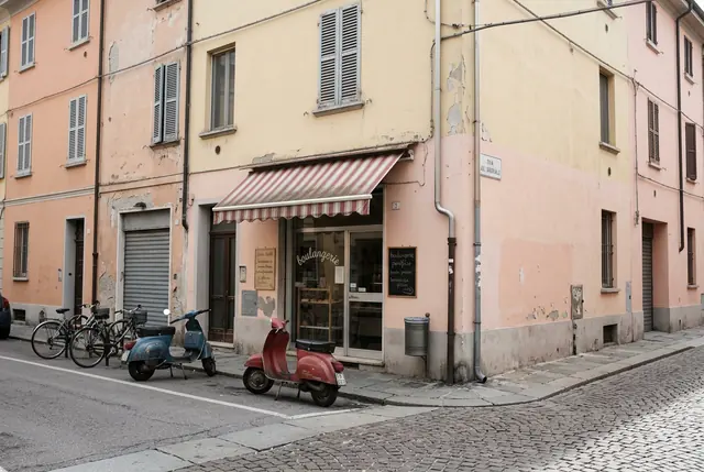 A plain midday phone photo of a European street corner with a bakery and two parked scooters (made with the model)
