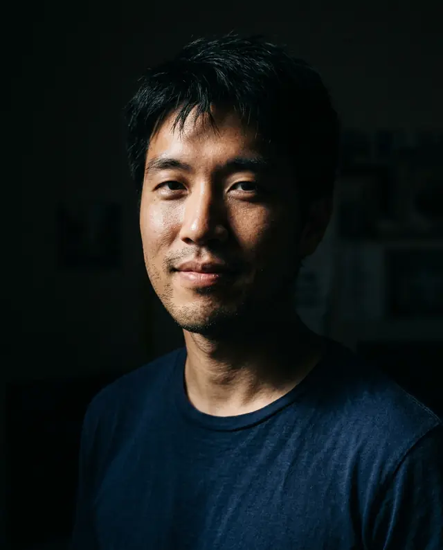 The same man lit by one hard side light against a dark background